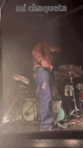 a man playing a guitar on stage with the words mi chaqueta on the bottom