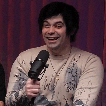 a man is smiling while holding a microphone in his hand .