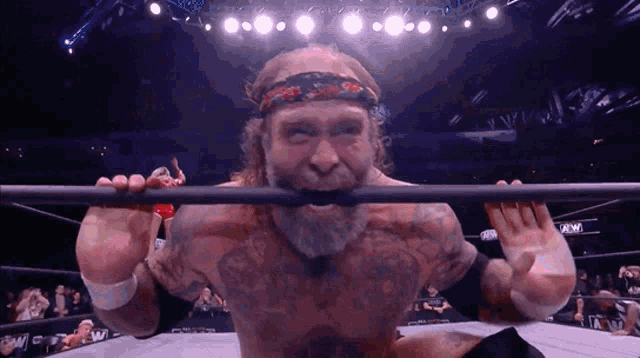 a man with a beard is holding a bar in his mouth