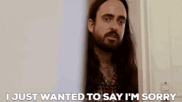 a man with long hair and a beard is saying i just wanted to say i 'm sorry