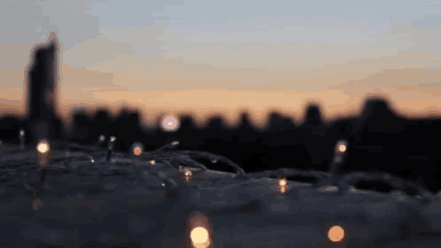 a blurry picture of a city skyline with a few lights in the foreground