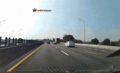a car is driving down a highway with the word wow tchout in the background
