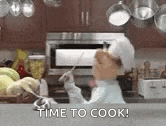 a muppet is cooking in a kitchen with the words `` time to cook '' written on the counter .