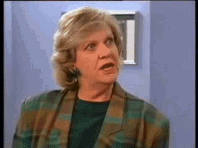 a woman in a plaid jacket is making a face