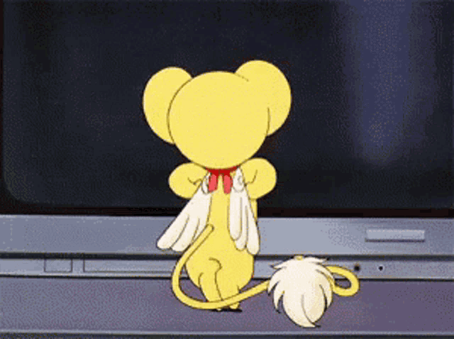 a cartoon character with wings and a tail is standing in front of a computer monitor