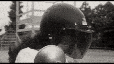 a black and white photo of a person wearing a helmet