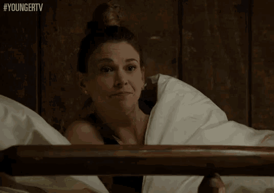a woman is sleeping in a bed with the hashtag youngertv on the bottom of the screen