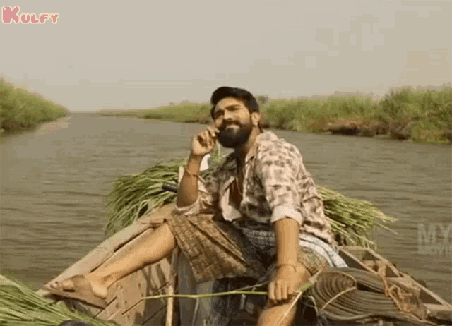 a man in a boat is talking on a cell phone .