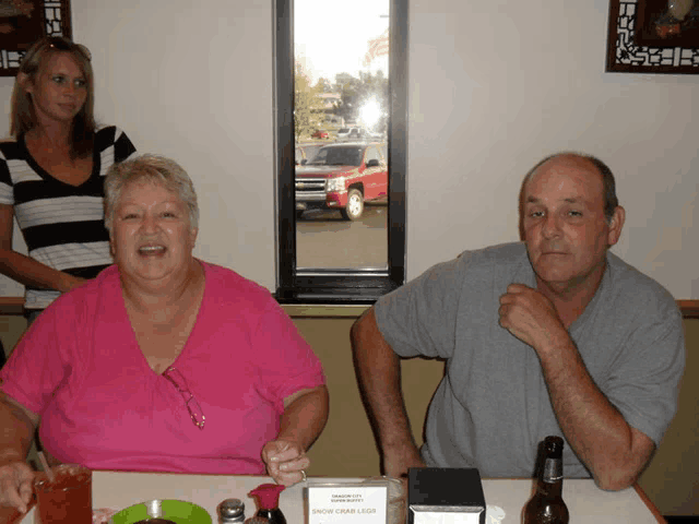 a man and a woman sit at a table with a napkin that says chow crab legs