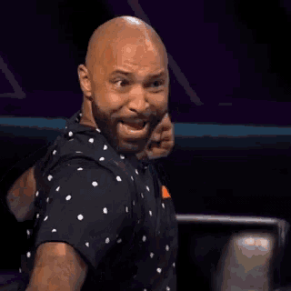 a bald man with a beard wearing a black shirt is dancing .