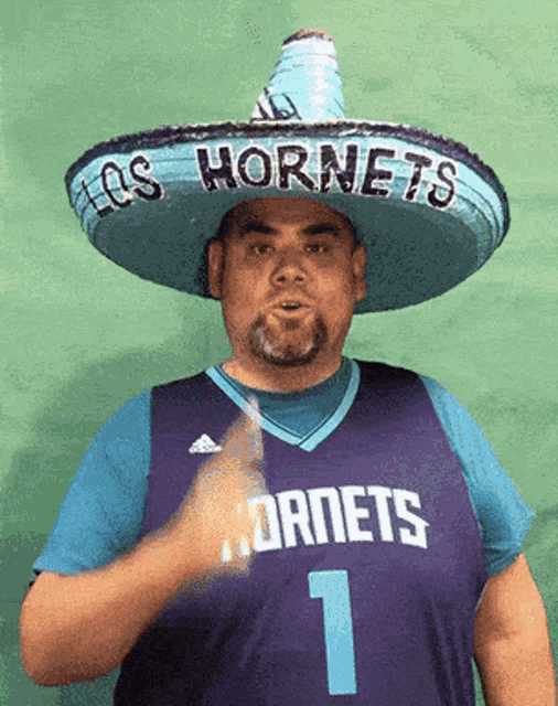 a man wearing a sombrero with los hornets on it