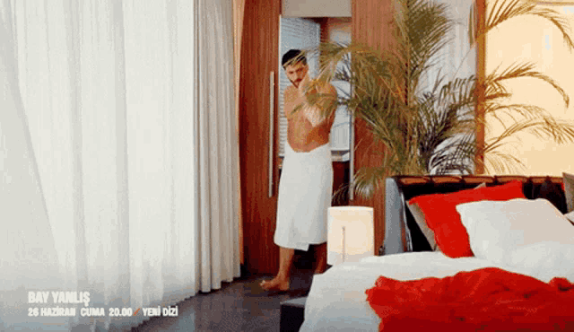 a man in a towel is standing in a bedroom with the date 26 haziran cuma 20.00