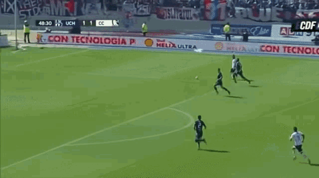 a soccer game is being played with a large pf logo on the sidelines