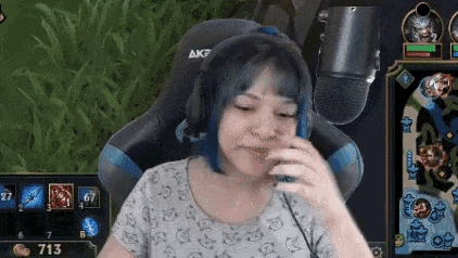 a woman wearing headphones and a microphone is sitting in a gaming chair .