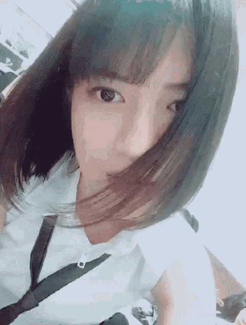 a woman with her hair blowing in the wind takes a selfie