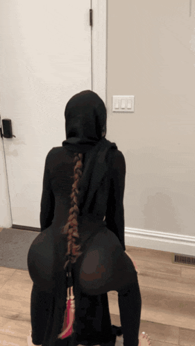 a woman with a braided back is wearing a black hoodie