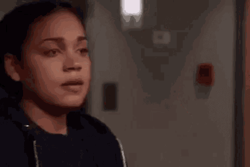 a close up of a woman covering her mouth with her hand in a room .