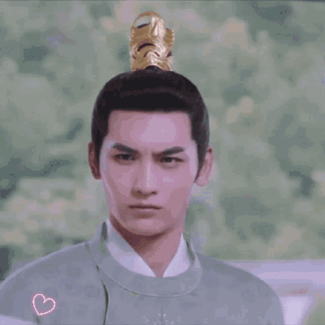 a man wearing a crown on his head is making a face .
