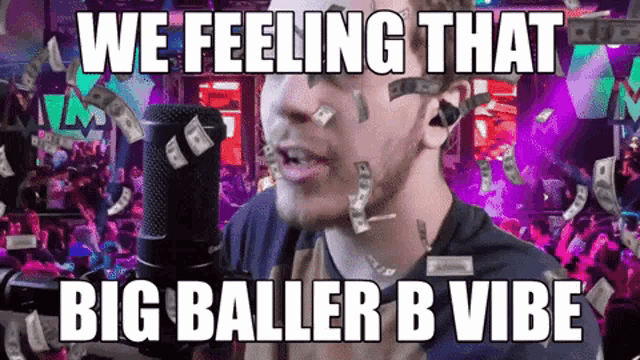 a man singing into a microphone with money falling on his face and the words we feeling that big baller b vibe below him