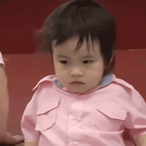 a little girl wearing a pink shirt with aa gif written on the bottom