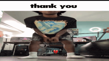 a man wearing a shirt that says thank you is standing in front of a desk