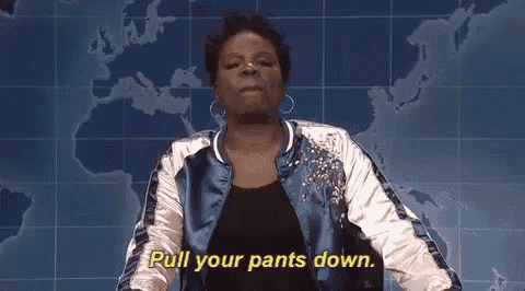 a woman in a blue jacket is standing in front of a map of the world and saying pull your pants down .