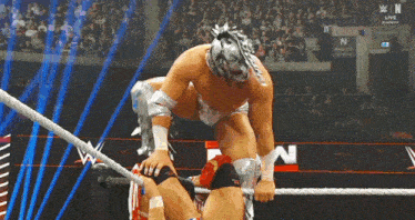 a man in a wrestling ring with a sign that says ' n live ' on it