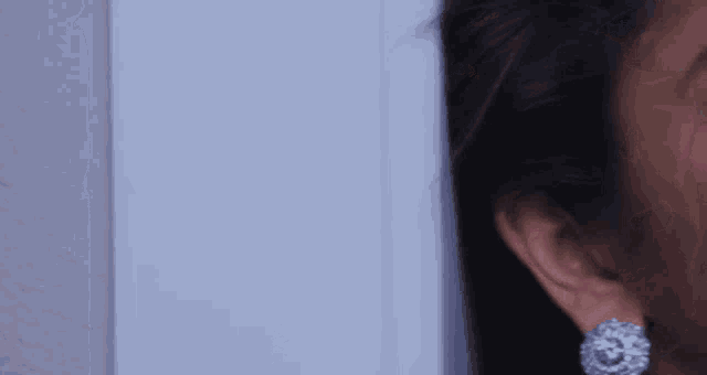 a close up of a woman 's ear with a white background