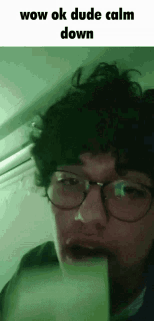 a man wearing glasses says wow ok dude calm down at the top of his face