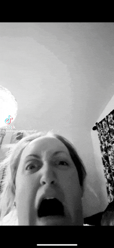 a black and white photo of a woman with her mouth open