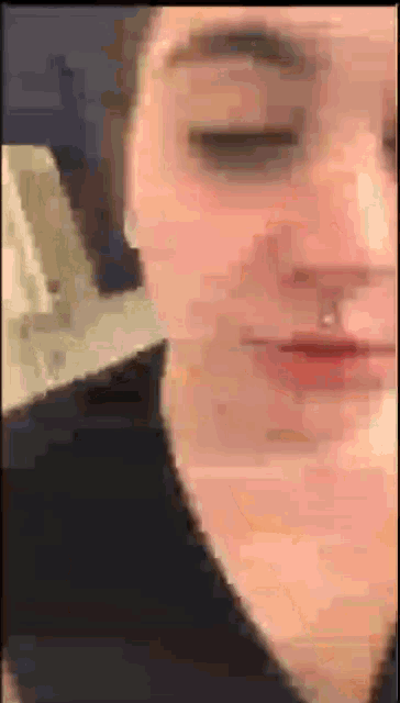 a blurry picture of a woman 's face with her eyes closed