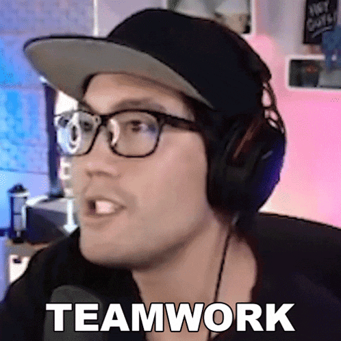 a man wearing glasses and headphones says teamwork in front of a microphone