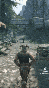 a video game character with horns is walking down a dirt road .