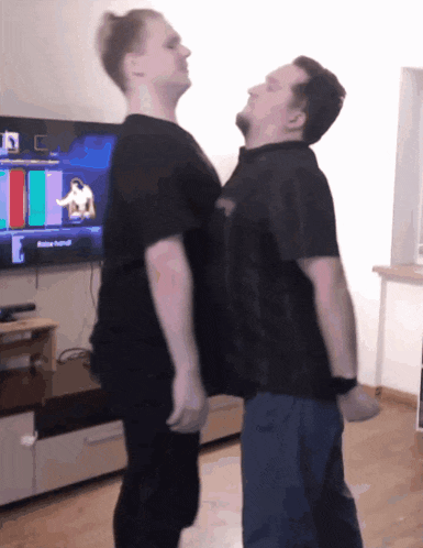 two men are standing next to each other in front of a tv that says action festival