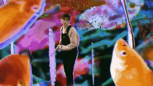 a man in overalls is standing in front of a fish tank surrounded by fish .
