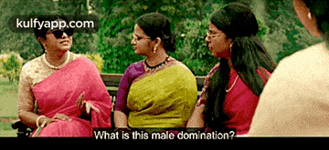 a group of women are sitting on a park bench and one of them is asking what is this male domination .