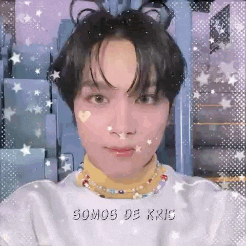 a close up of a person wearing a turtleneck and a necklace with the words `` somos de kris '' on it .