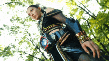 a woman in a black and gold outfit is holding a sword