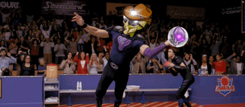 a man wearing a helmet is throwing a frisbee in front of a crowd with a sign that says streetshow on it