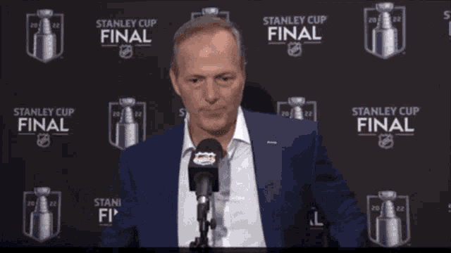 a man in a blue suit is talking into a microphone and says the great thing about today is that it 's not yester