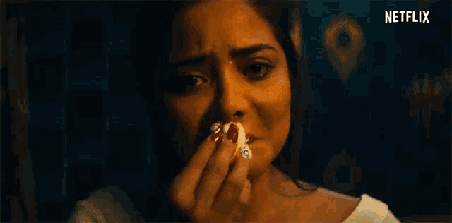 a woman is crying while holding a piece of bread in her hand .