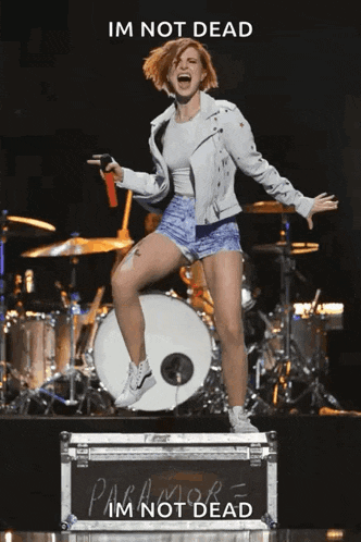a woman is jumping in the air while standing on a case that says paramore i 'm not dead