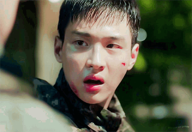 a close up of a man 's face with a red spot on his face