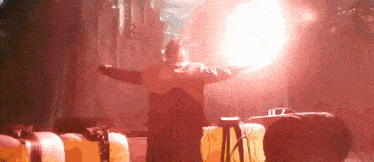 a man with his arms outstretched is standing in front of a red light .