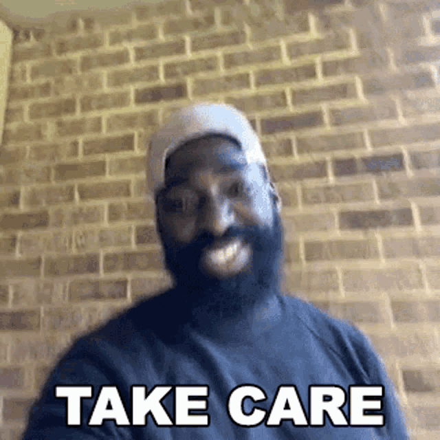 a man with a beard is smiling and says `` take care '' .