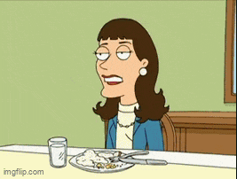 a woman is sitting at a table with a plate of food and a glass of milk
