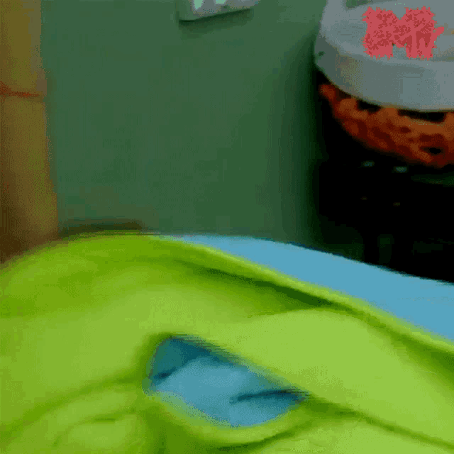 a green blanket is laying on a blue bed