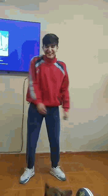 a young man is dancing in front of a television .