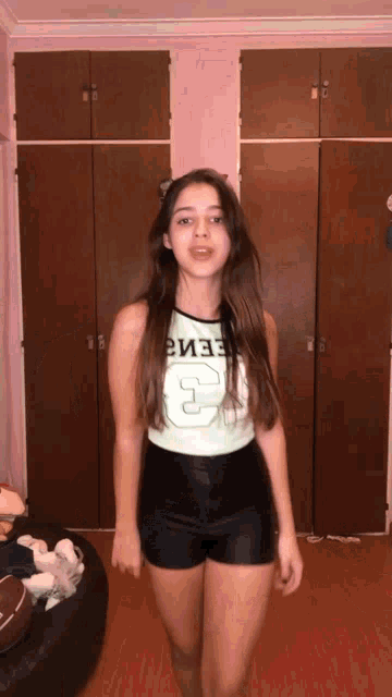a girl wearing shorts and a tank top that says 3