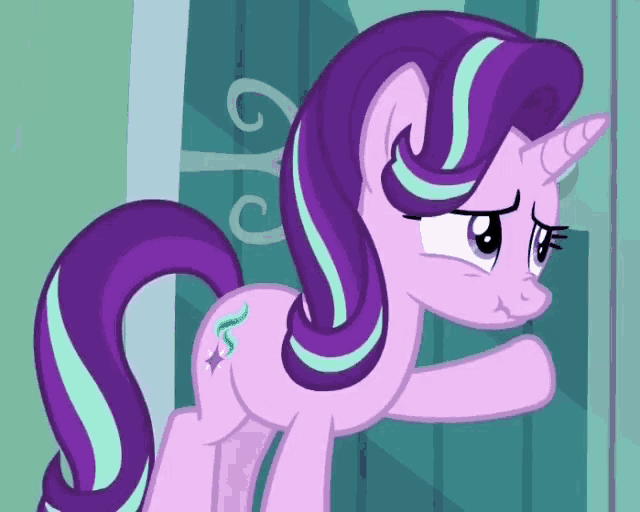 a purple pony with a unicorn horn is standing in front of a blue wall .
